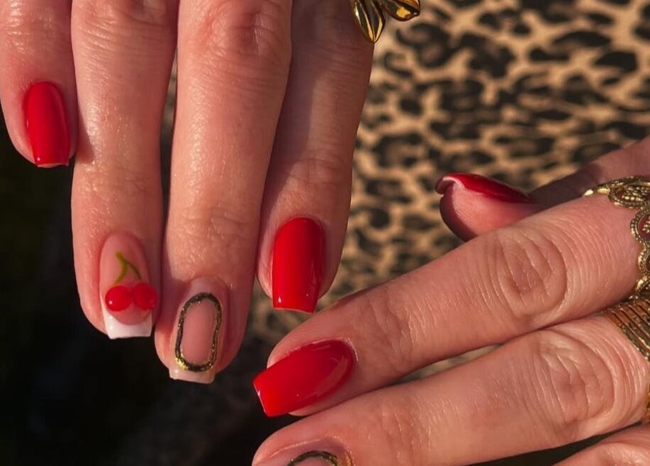 Ongles rouges avec motifs cerise au Romynails pro, Genvry, Hauts-de-France, FR. Nail art éclatant et tendance.