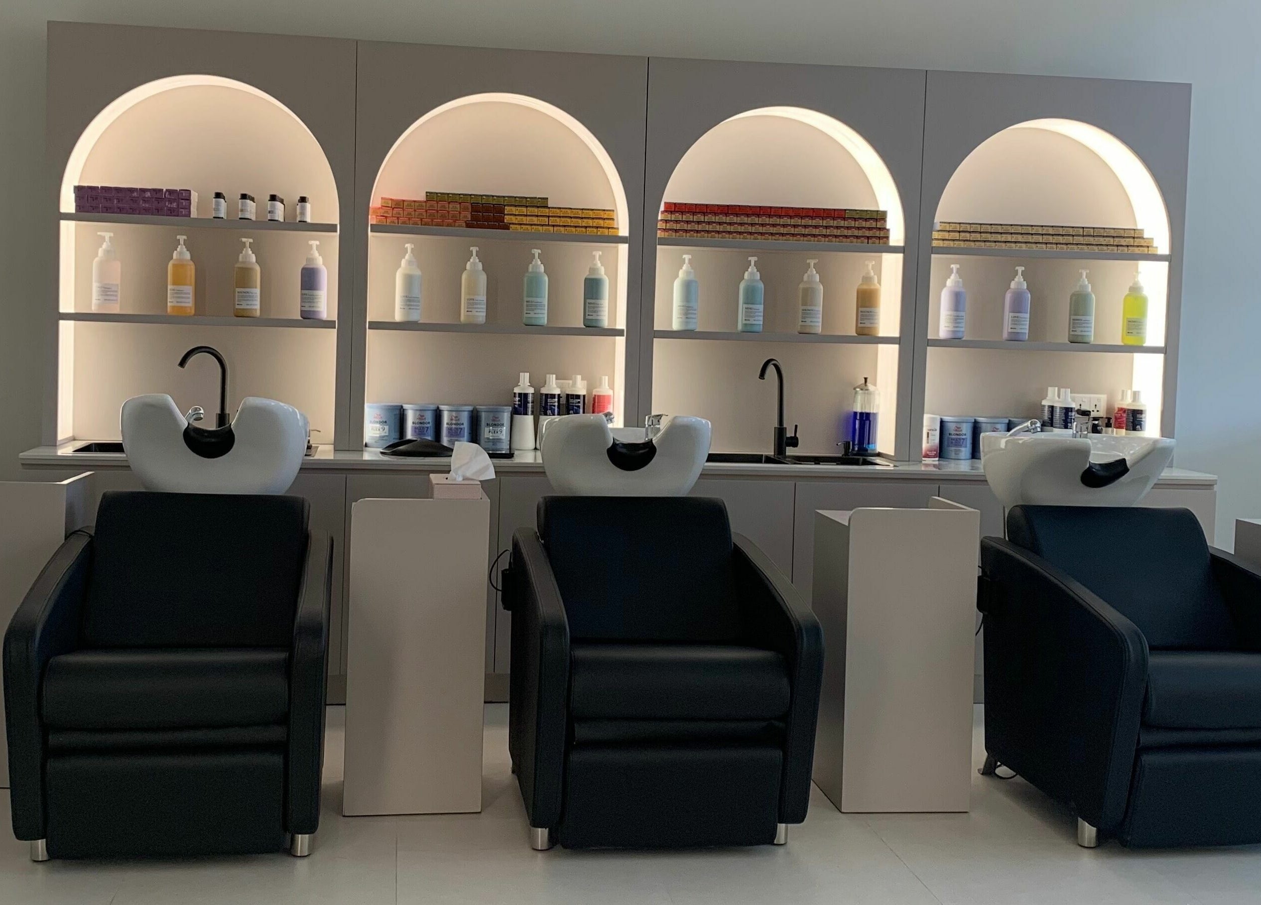 Modern hair wash stations at Sasalon Dubai, Dubai, AE. Sleek black chairs and premium hair products displayed stylishly.