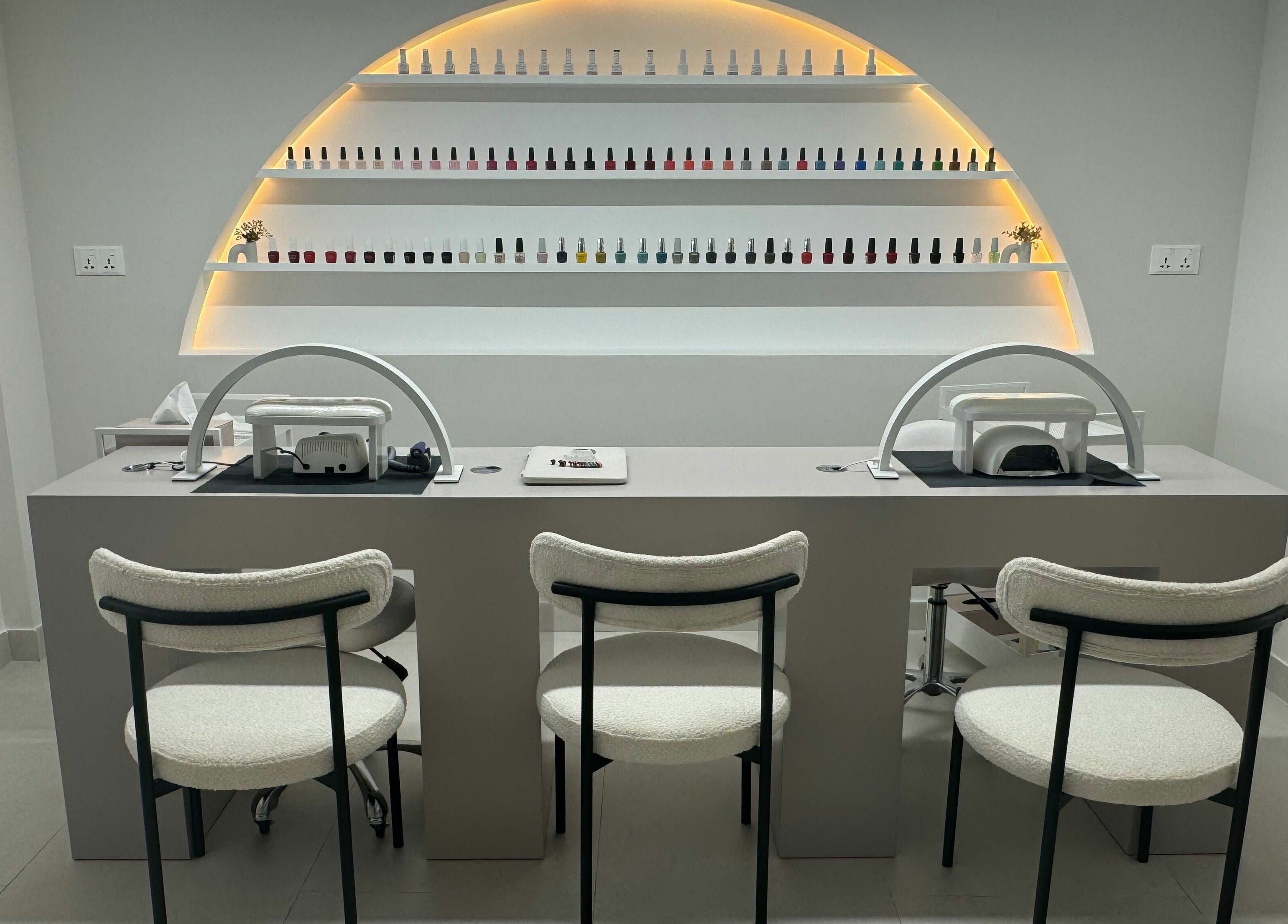 Modern nail salon section in Sasalon Dubai, Dubai, AE with chic chairs and polished nail color display.