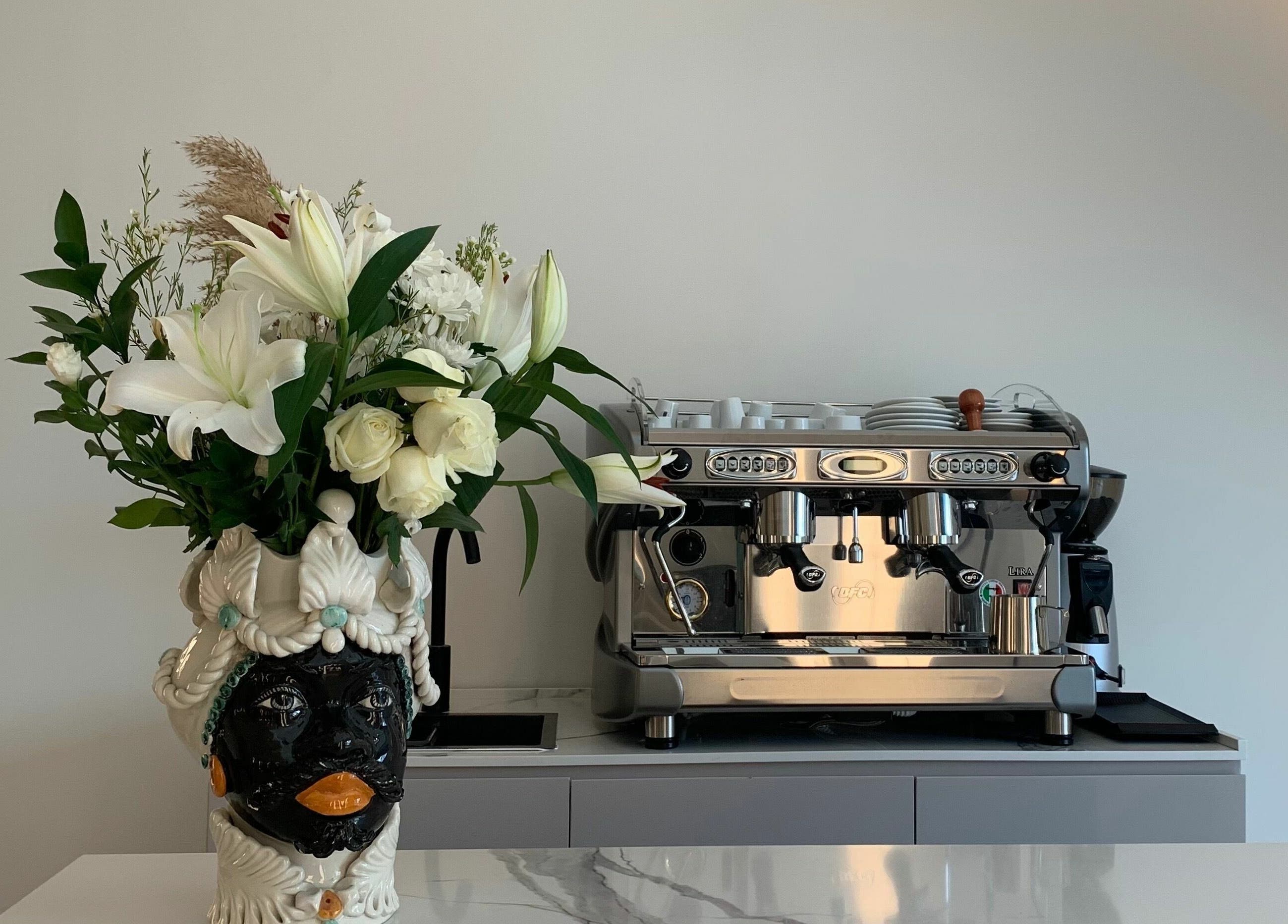 Coffee nook with floral centerpiece at Sasalon Dubai, Dubai, AE, offering a welcoming and stylish ambiance.