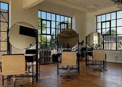 Bright, spacious salon area at Solar Haar at Studio 90, London, England, GB with modern styling chairs and mirrors.