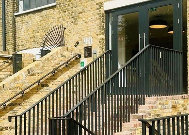 Entrance of Solar Haar at Studio 90 in London, England, GB with modern black railing on brick steps.