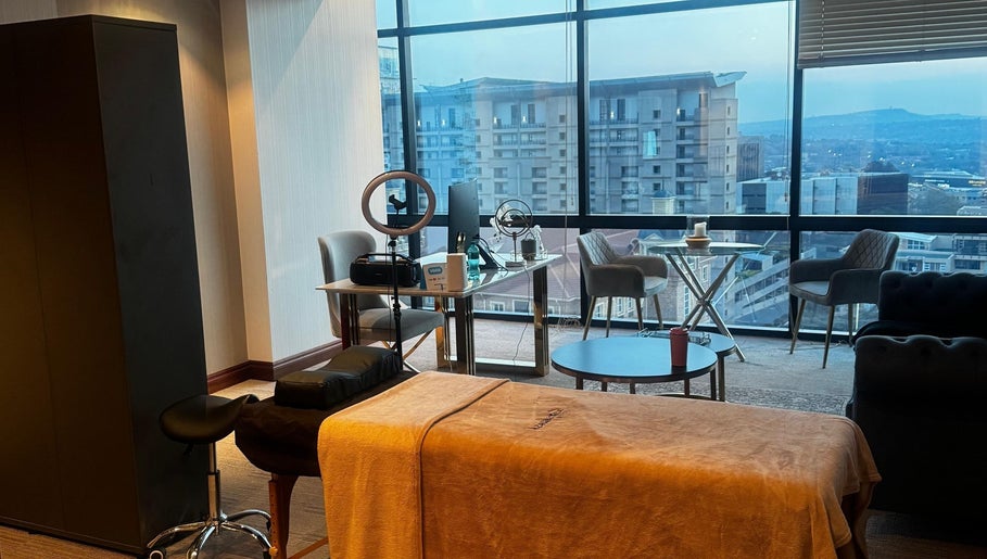 Modern wellness suite at Aestheticsby.Yas in Sandton, Gauteng, ZA with massage bed and city view.