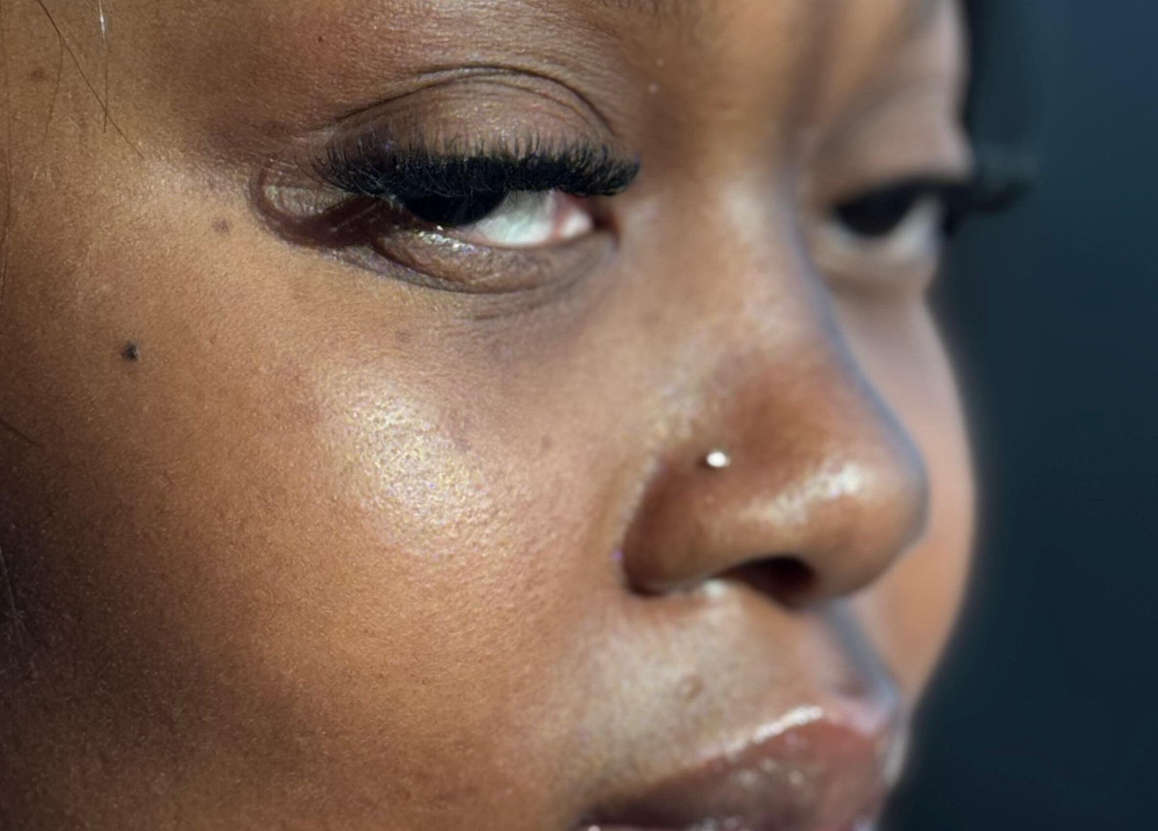 Close-up of a woman's radiant skin with a nose piercing at Aestheticsby.Yas in Sandton, Gauteng, ZA.