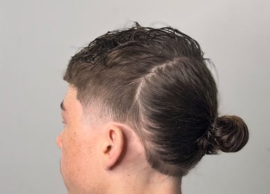 Side view of a modern men's hairstyle with bun at Fergo Blends, Leppington, New South Wales, AU.