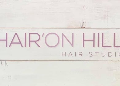 Hair’On Hill sign at Caledon, Northern Ireland, GB. Elegant salon branding on a wooden texture.