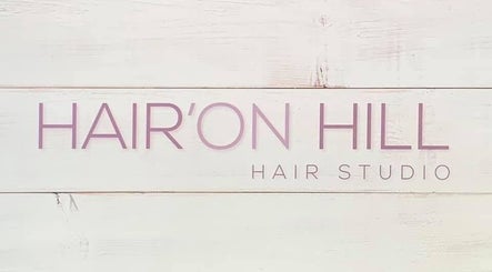 Hair’On Hill sign at Caledon, Northern Ireland, GB. Elegant salon branding on a wooden texture.