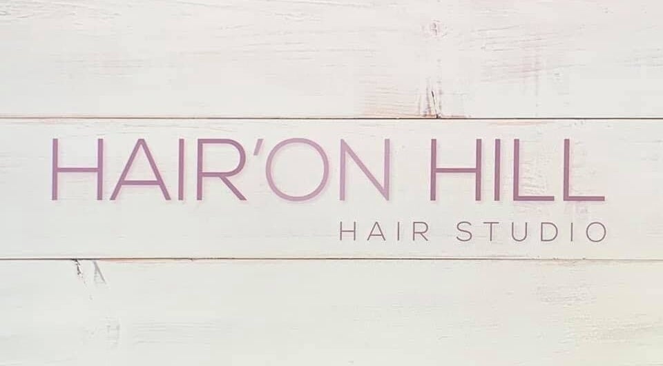 Hair’On Hill sign at Caledon, Northern Ireland, GB. Elegant salon branding on a wooden texture.