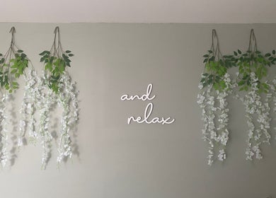 Wall with cascading vines and 'and relax' sign at Massage & Wellness Sanctuary, Winchburgh, Scotland, GB.