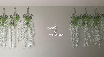 Wall with cascading vines and 'and relax' sign at Massage & Wellness Sanctuary, Winchburgh, Scotland, GB.
