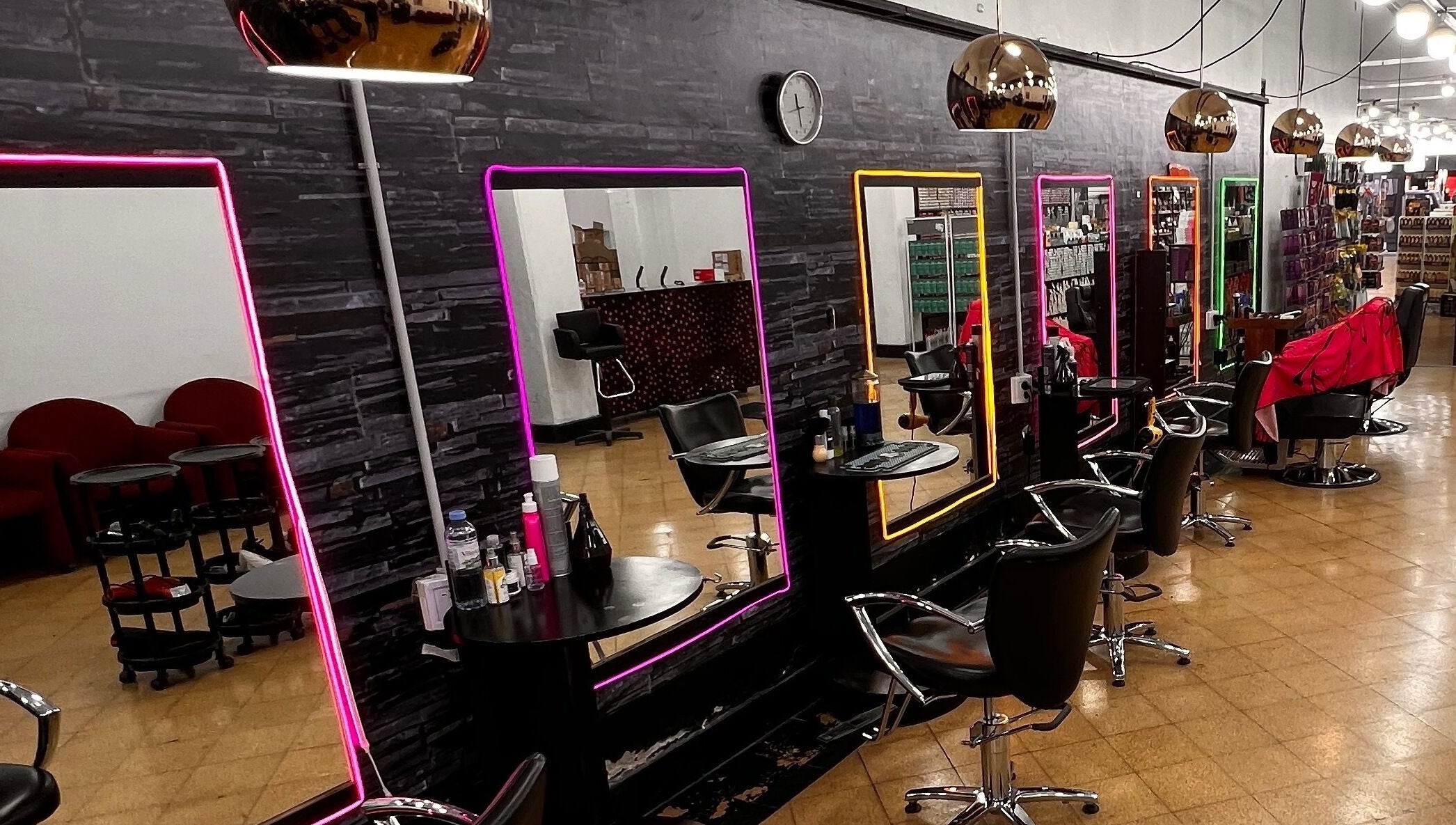 Interior moderno de Espacio Evo Colón en Córdoba, Córdoba, AR con espejos iluminados y sillas elegantes.