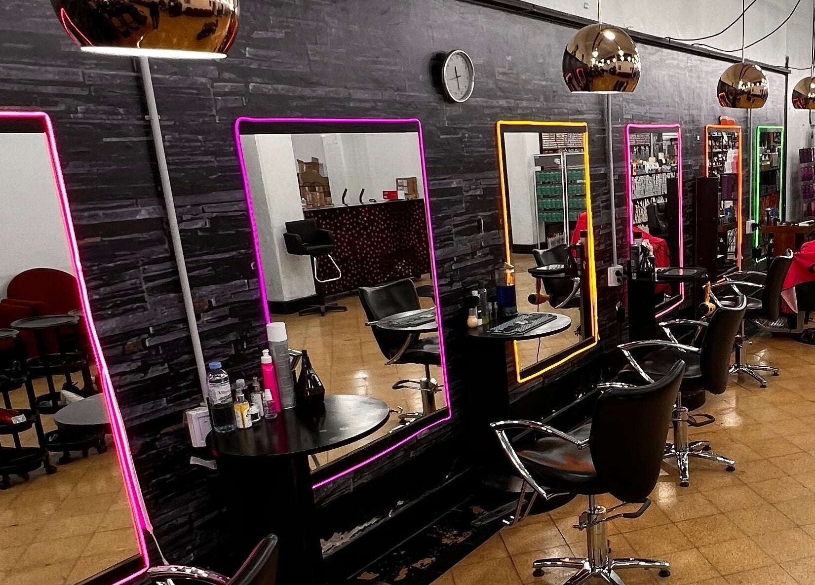 Interior moderno de Espacio Evo Colón en Córdoba, Córdoba, AR con espejos iluminados y sillas elegantes.