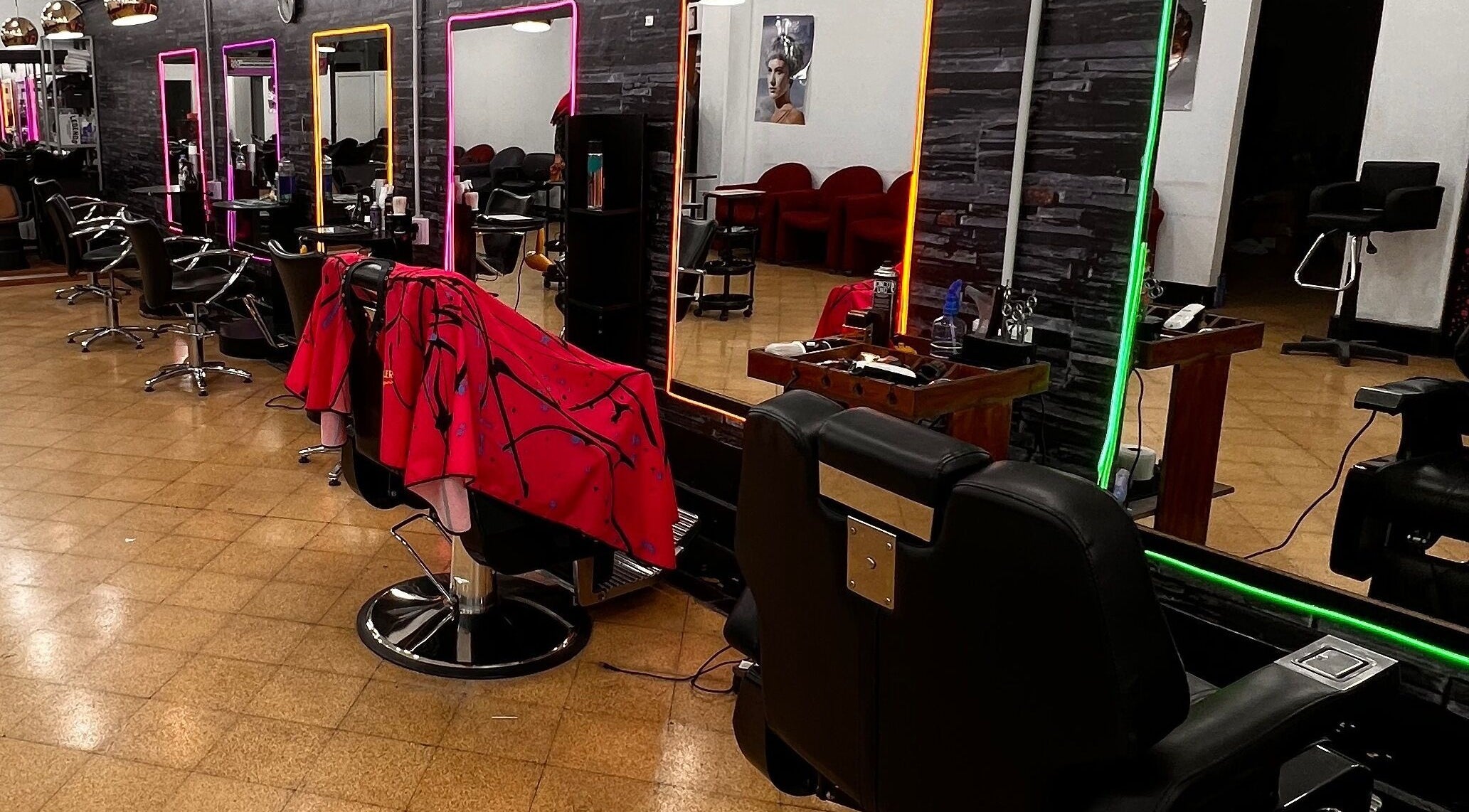 Interior moderno de Espacio Evo Colón en Córdoba, Córdoba, AR, con espejos iluminados y sillas de peluquería.