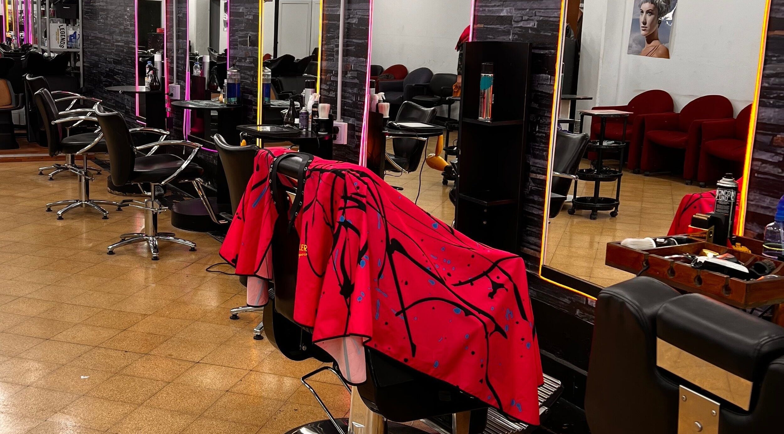 Interior moderno de Espacio Evo Colón en Córdoba, AR, mostrando sillas de peluquería y espejos iluminados.