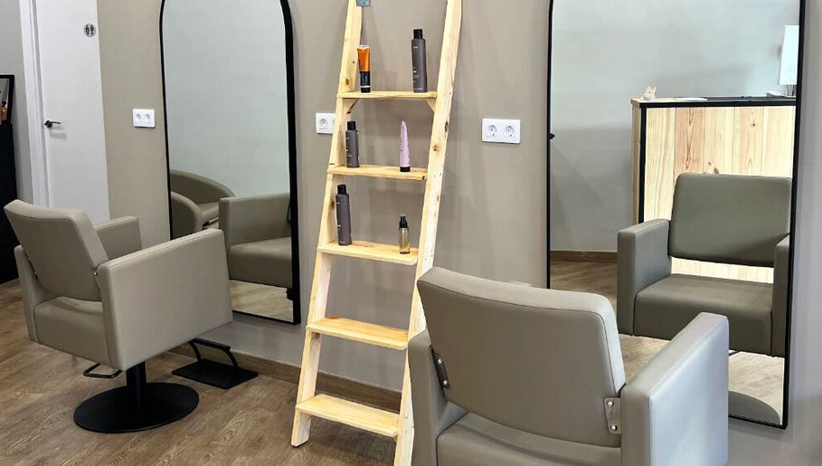 Interior de SV Saray Valdivia Beauty Hair Studio en Sabadell, Catalunya, ES, con asientos modernos y espejo grande.