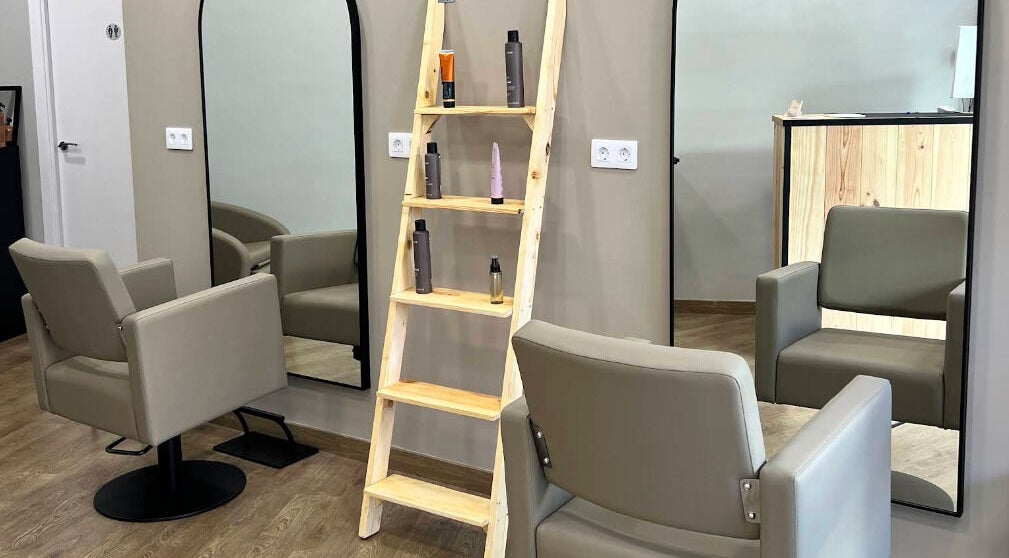 Interior de SV Saray Valdivia Beauty Hair Studio en Sabadell, Catalunya, ES, con asientos modernos y espejo grande.