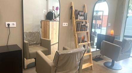 Interior de SV Saray Valdivia Beauty Hair Studio en Sabadell, Catalunya, ES, mostrando sillas y productos de belleza.