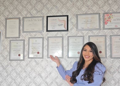 Profissional sorri mostrando certificados na parede do Studio Maye Miranda - Calvão, Calvão, Aveiro, PT.