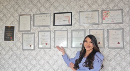 Profissional sorri mostrando certificados na parede do Studio Maye Miranda - Calvão, Calvão, Aveiro, PT.