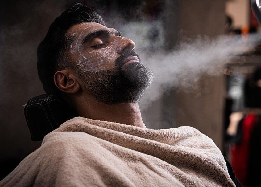 Man enjoys a steam facial at Spartan Barber WLL in Saar, Al-muḥāfaẓat Aš-šamālīyah, BH.