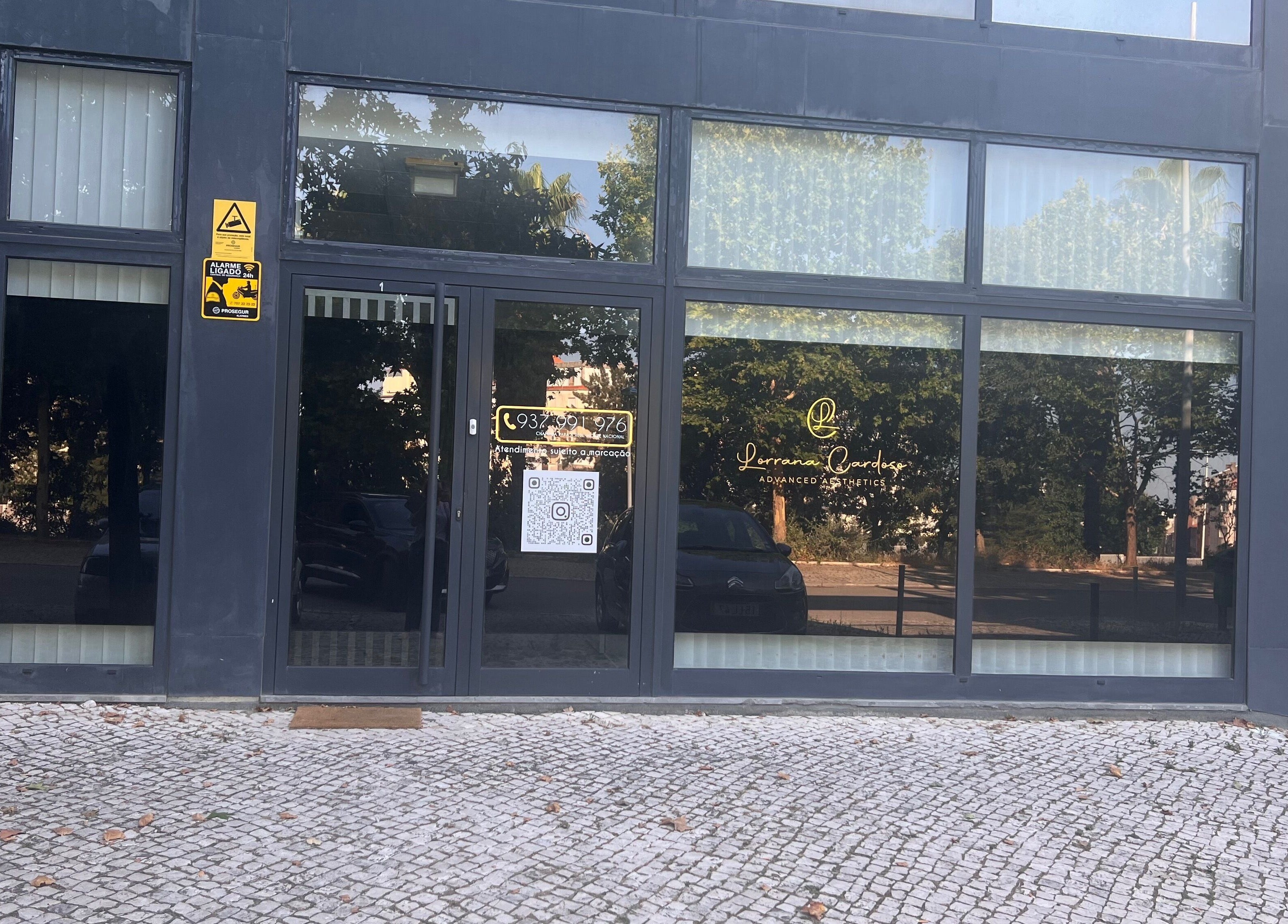 Entrada de Lorrana Cardoso - Estética Avançada em Moscavide, Lisboa, PT, com grandes janelas de vidro.