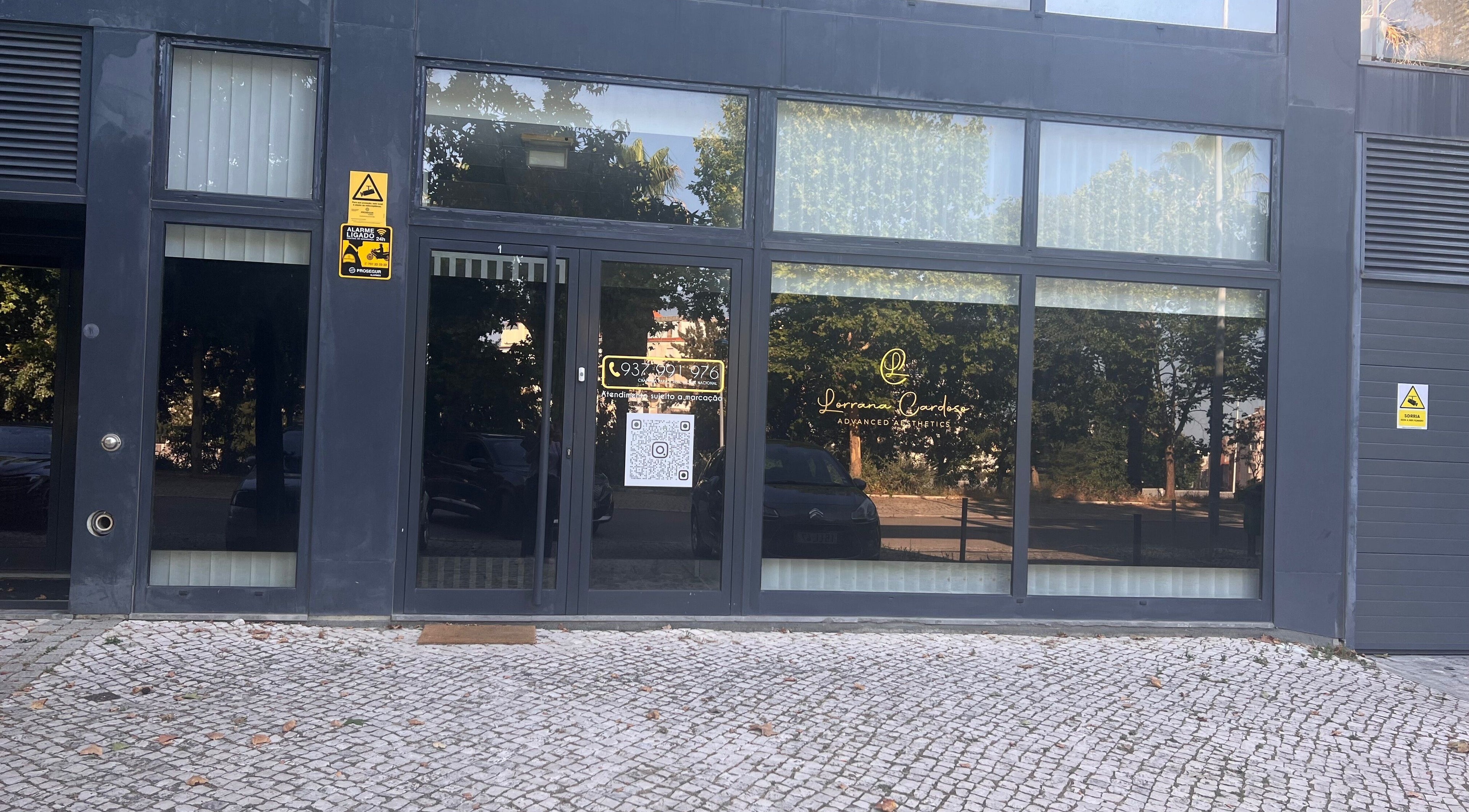 Entrada de Lorrana Cardoso - Estética Avançada em Moscavide, Lisboa, PT, com grandes janelas de vidro.
