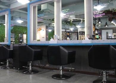 Modern salon interior at THT - That Hair Tho, Dubai, Dubai, AE featuring stylish black chairs and mirrors.