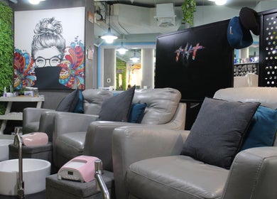 Stylish pedicure lounge at THT - That Hair Tho, Dubai, Dubai, AE with plush chairs and artistic decor.