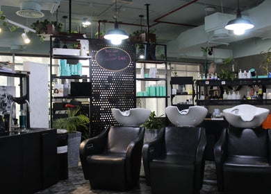 Modern salon interior at THT - That Hair Tho, Dubai, Dubai, AE with stylish wash stations and product shelves.