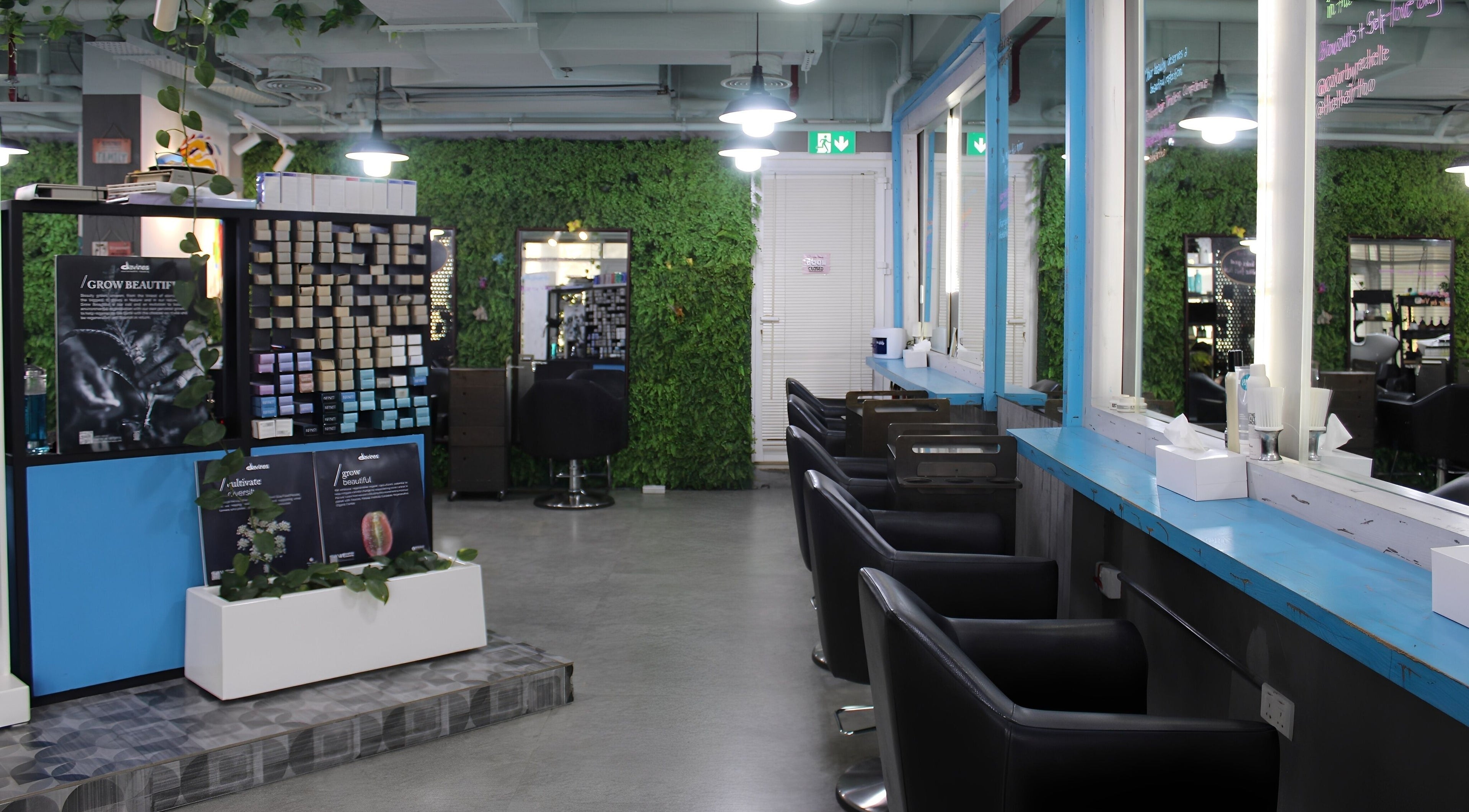 Modern salon interior at THT - That Hair Tho, Dubai, Dubai, AE, showcasing sleek styling chairs and lush decor.