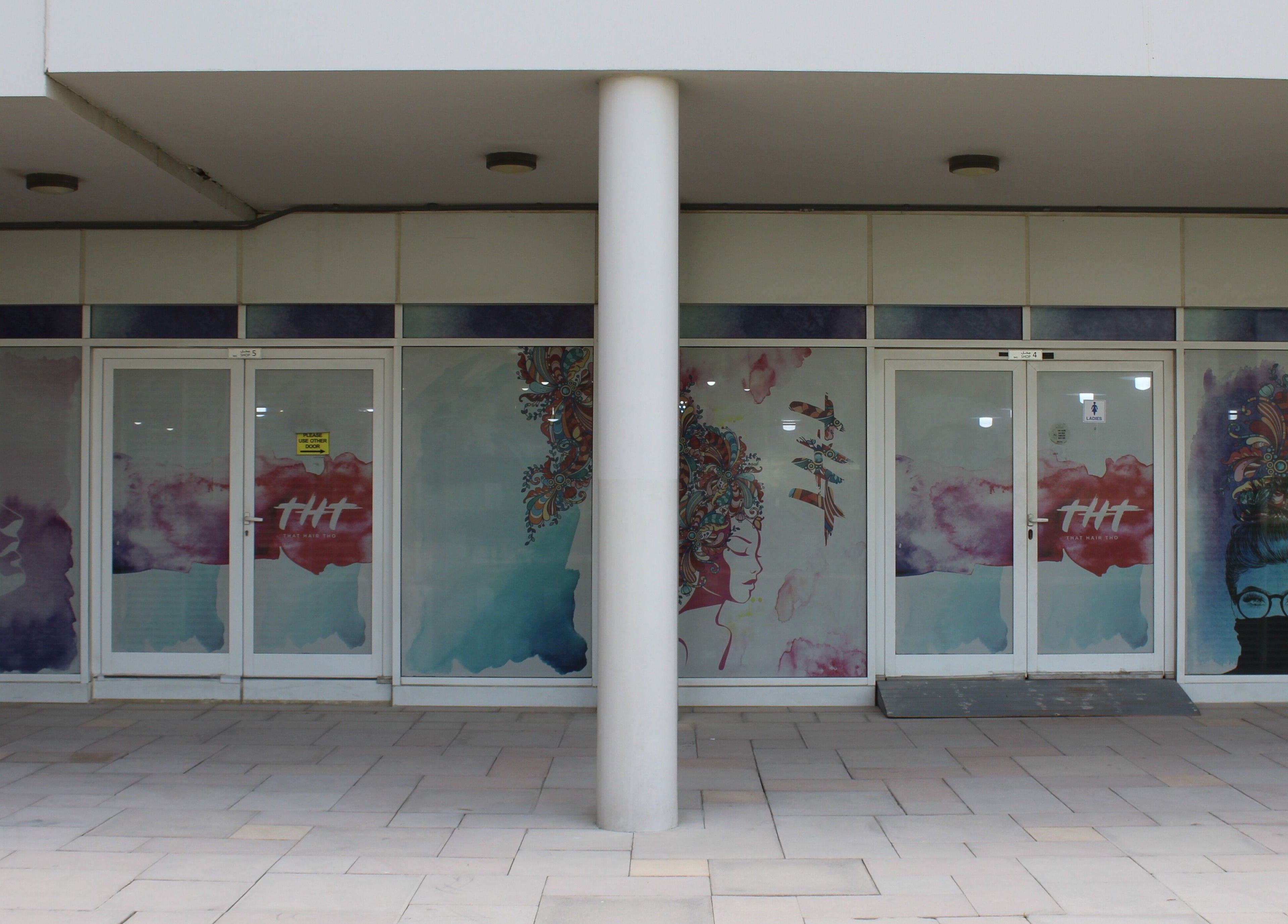 Front entrance of THT - That Hair Tho salon in Dubai, Dubai, AE with artistic window graphics.