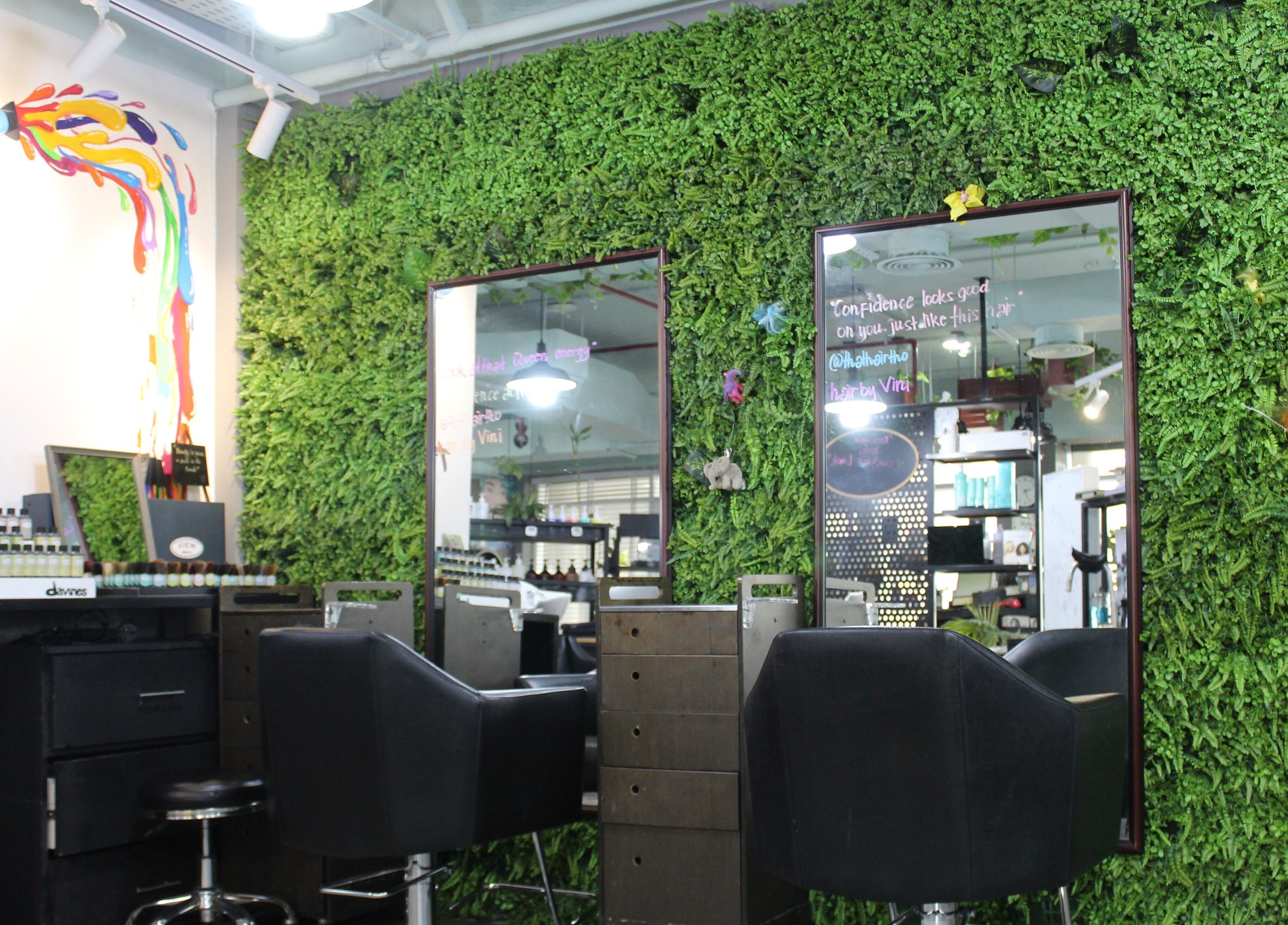 THT - That Hair Tho salon in Dubai, with chic chairs and a vibrant green wall.