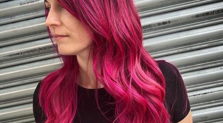 Bright pink hair styled at POP West Norwood, London, England, GB against a metal backdrop.