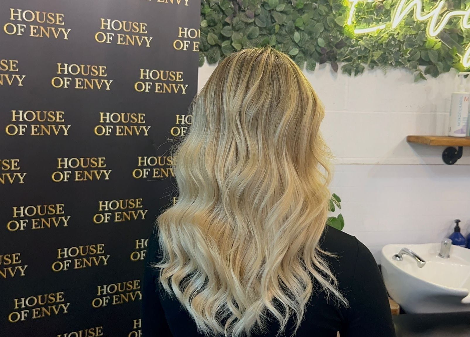 Blonde hair styled at House Of Envy Longford in Gloucester, England, GB with vibrant backdrop.