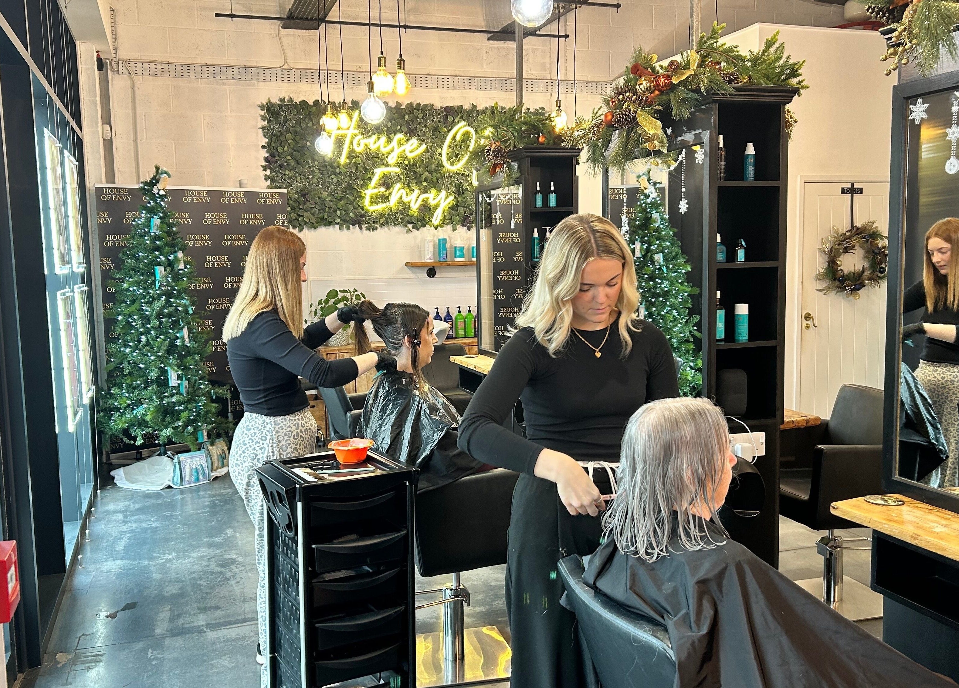 Stylists at House Of Envy Longford in Gloucester, England, GB creating beautiful hairstyles amidst festive decor.