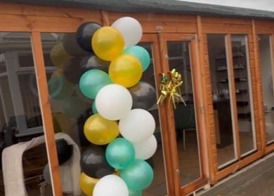 Elegant balloon display at Wings of Beauty, Leeds, England, GB, enhancing the wooden entrance.