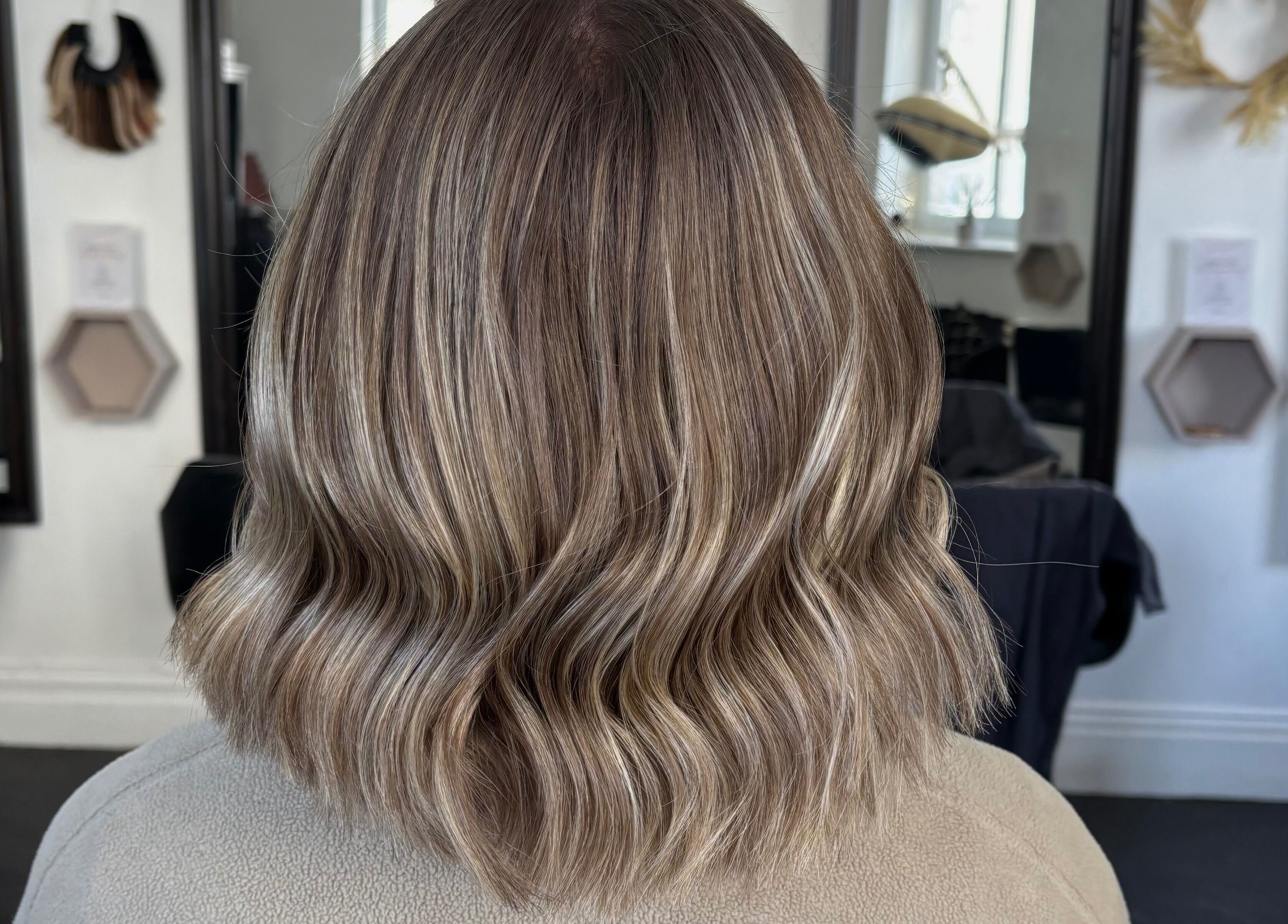 Stylish wavy hairstyle at Hair by Lottie, Weston-super-Mare, England, GB. Modern salon interior.