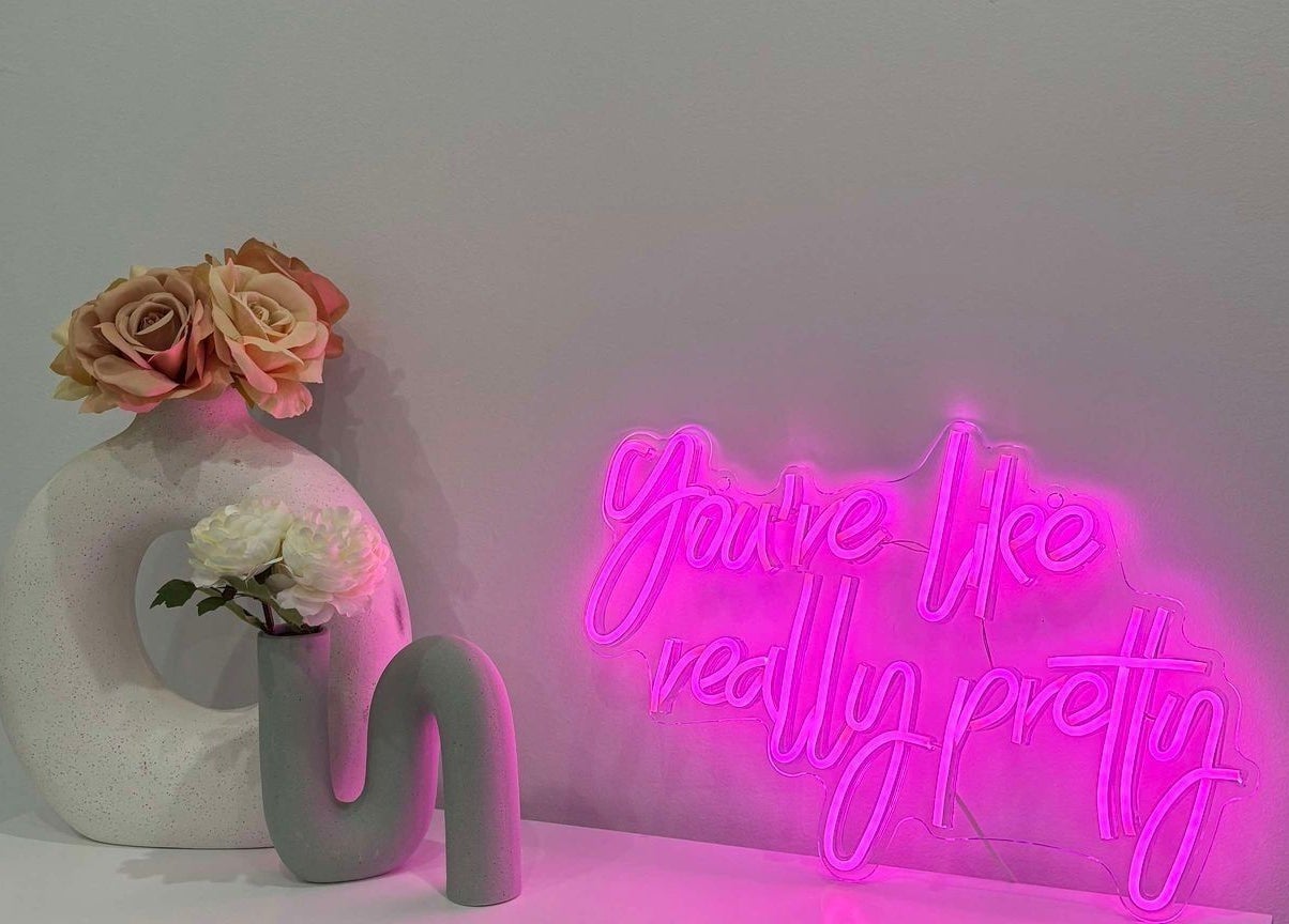 Decorative vase with roses next to neon sign at TMC Lifestyle & Aesthetics, Wagga Wagga, New South Wales, AU.