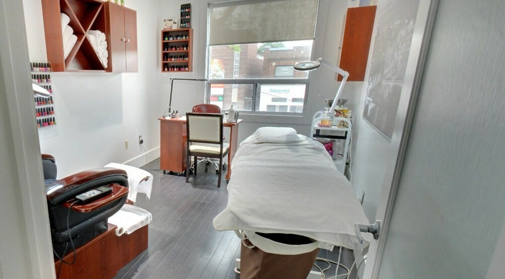 Modern spa room at Skin and Bodyfresh Med Clinic + Spa in Toronto, Ontario, CA, featuring a treatment bed and nail station.