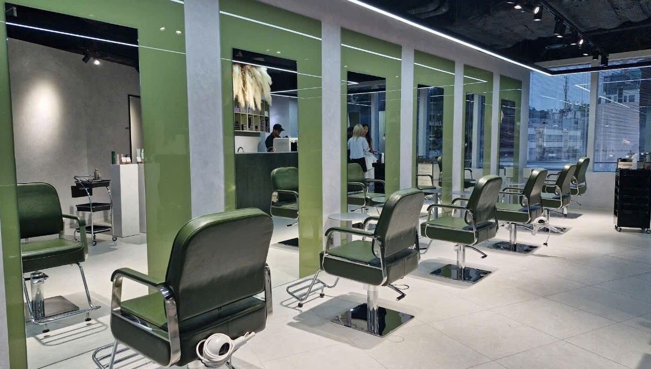 Modern salon interior at LEEKAJA Diamond Plaza in Hồ Chí Minh, featuring chic green chairs and sleek design.