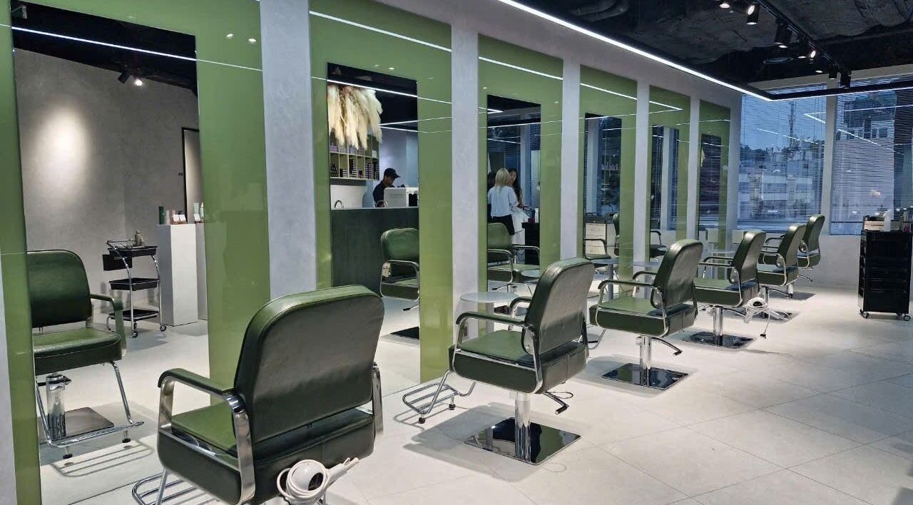 Modern salon interior at LEEKAJA Diamond Plaza in Hồ Chí Minh, featuring chic green chairs and sleek design.