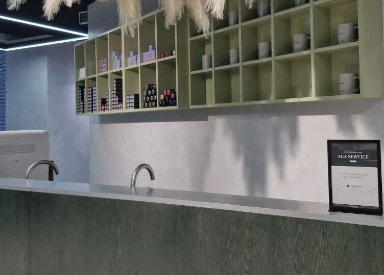 Sleek reception at LEEKAJA Diamond Plaza, Hồ Chí Minh, VN with modern shelving and tea service.