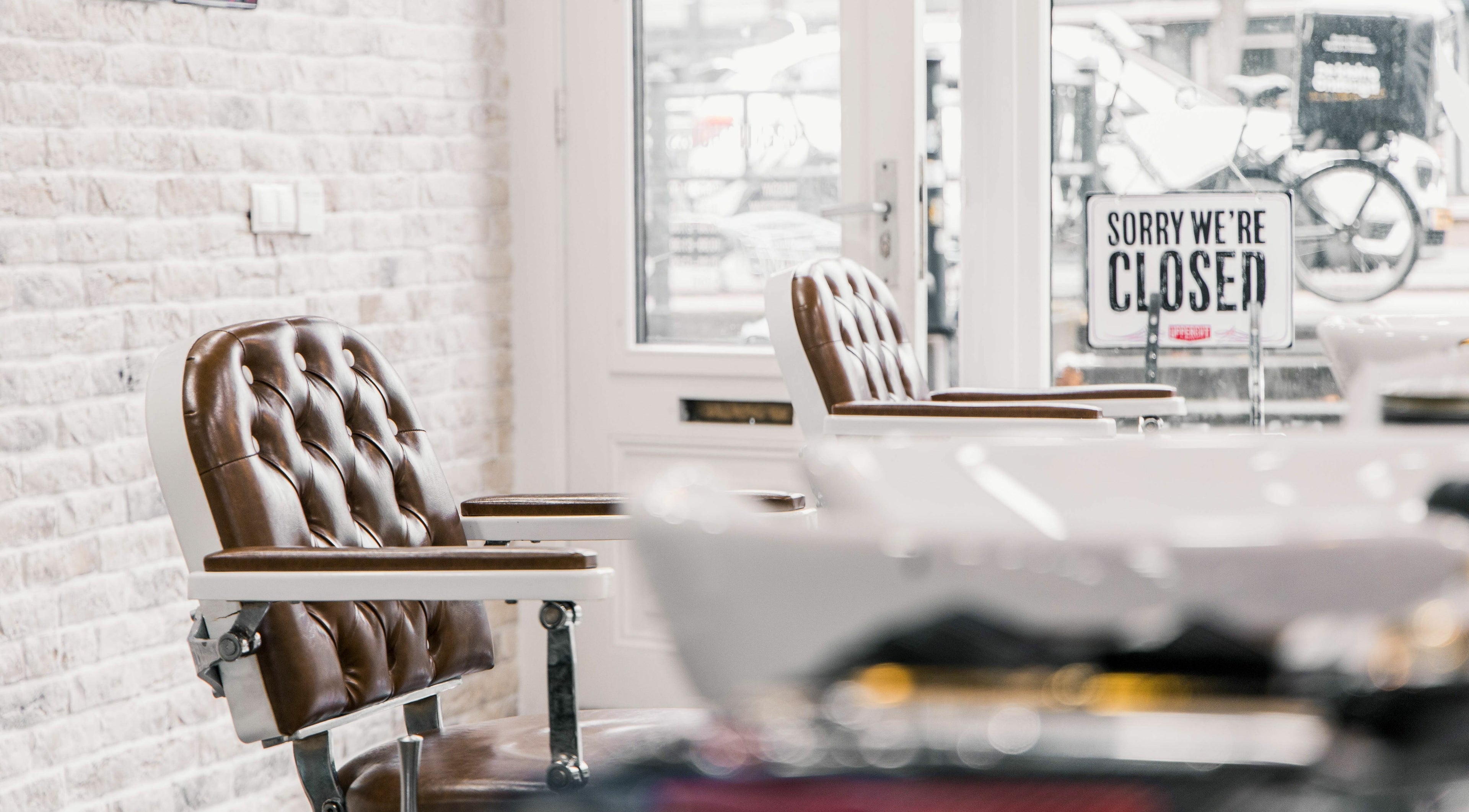 Stylish barbershop chairs at Strak Strak - Barbershop, Rotterdam, South Holland, NL, with closed sign.