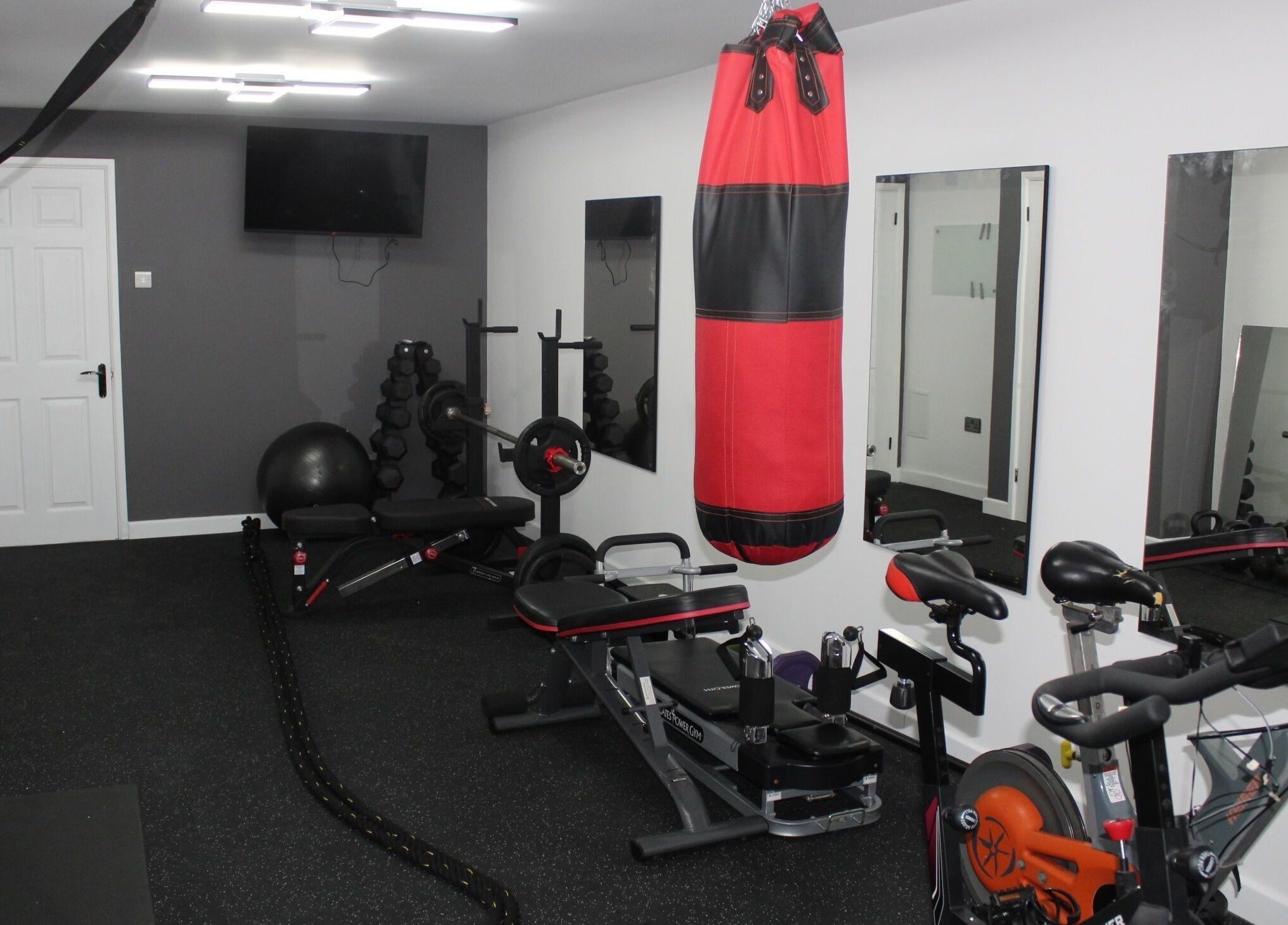 Modern gym setup at Valkyrie Performance and Aesthetics, Norwich, England, GB with cycling and boxing equipment.
