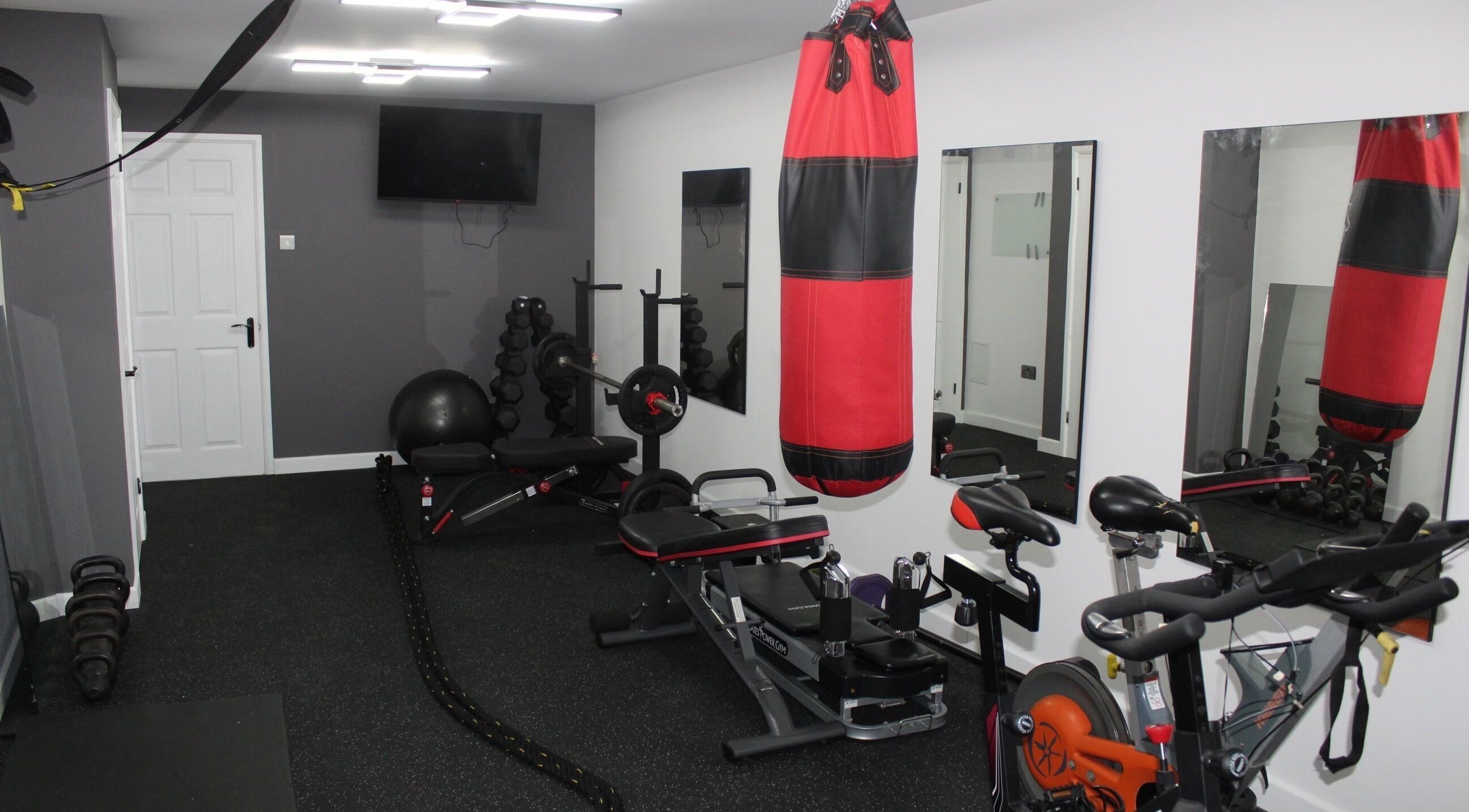 Modern gym setup at Valkyrie Performance and Aesthetics, Norwich, England, GB with cycling and boxing equipment.