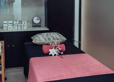 Relaxing treatment room at The Glam Lounge in Berea, Kwazulu-natal, ZA, featuring a massage bed and skincare products.
