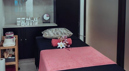 Relaxing treatment room at The Glam Lounge in Berea, Kwazulu-natal, ZA, featuring a massage bed and skincare products.