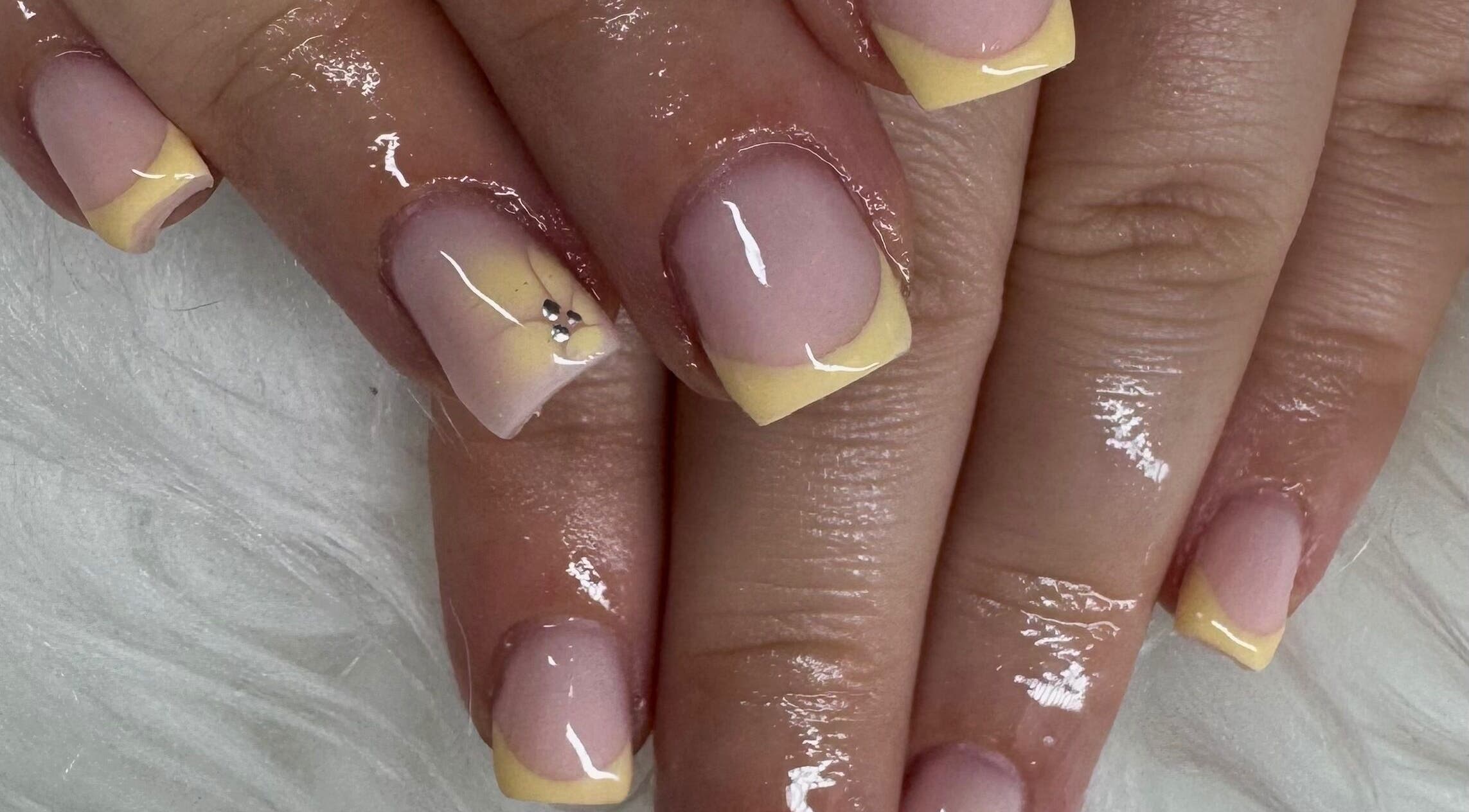 Pastel yellow manicure with gems at Nailsbysoph Xox, Ruthin, Wales, GB.