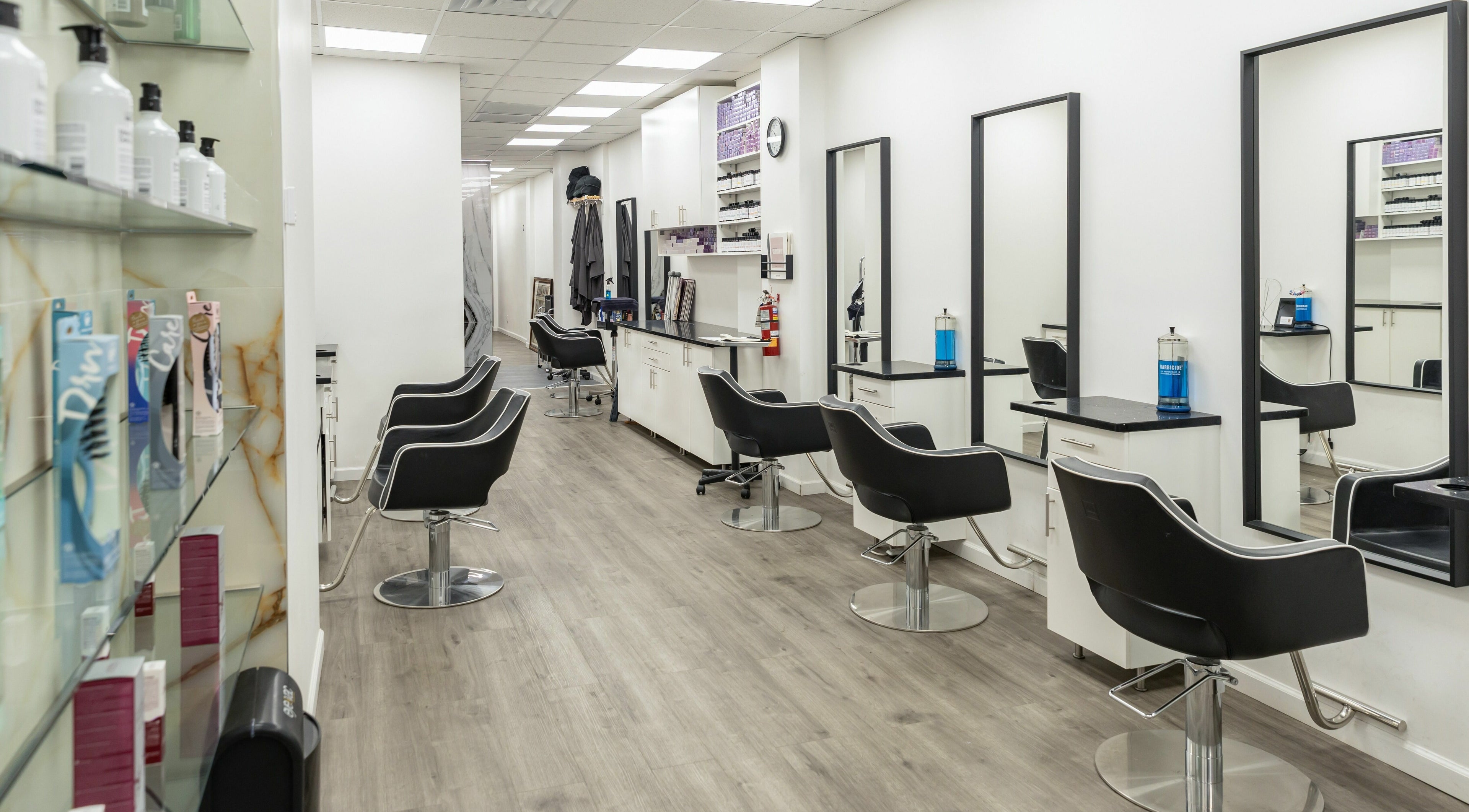 Spacious, modern salon at Balayage Bliss in New York, New York, US with stylish chairs and mirrors.