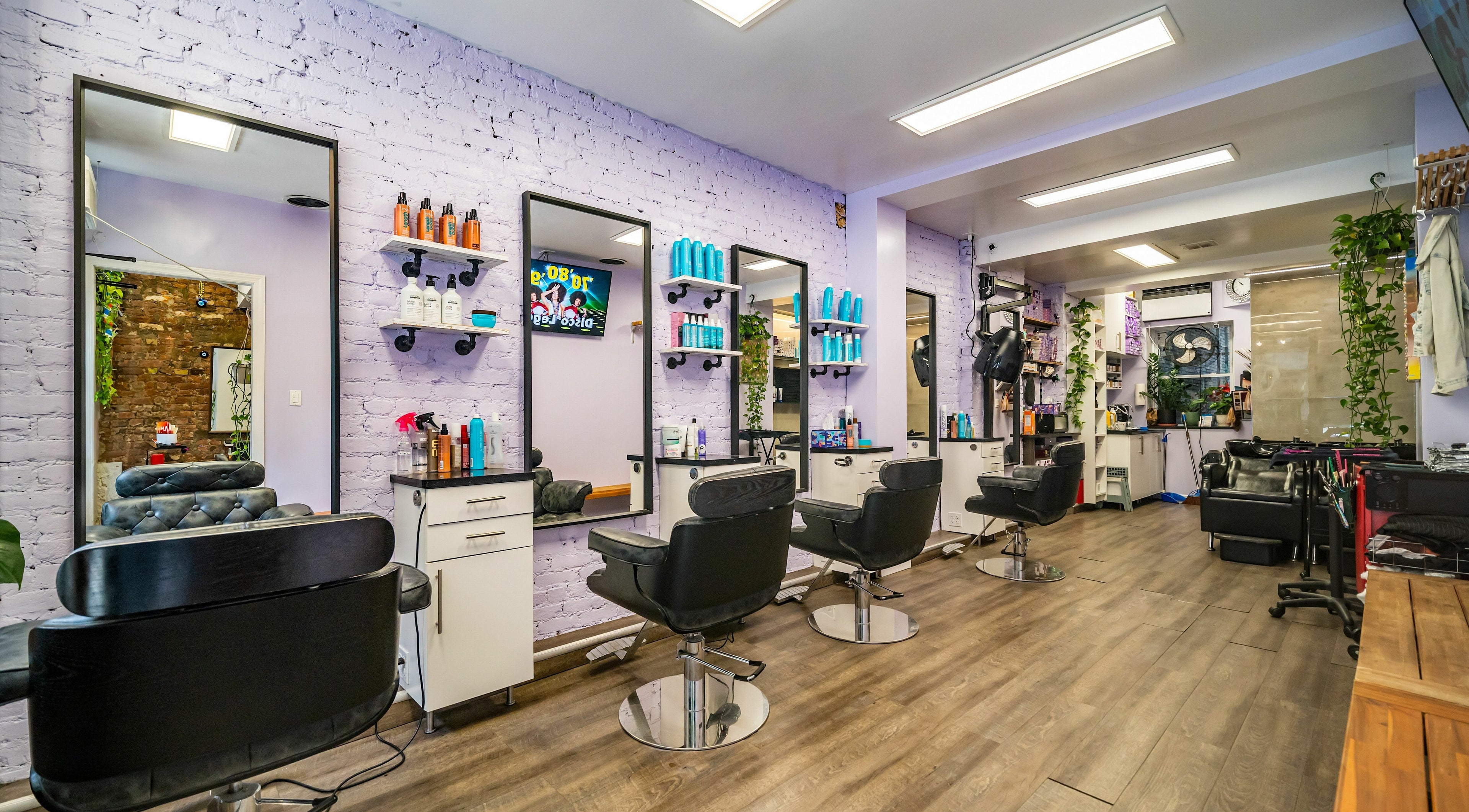 Modern interior of Balayage Me Hair Salon in New York, New York, US, featuring stylish chairs and mirrors.